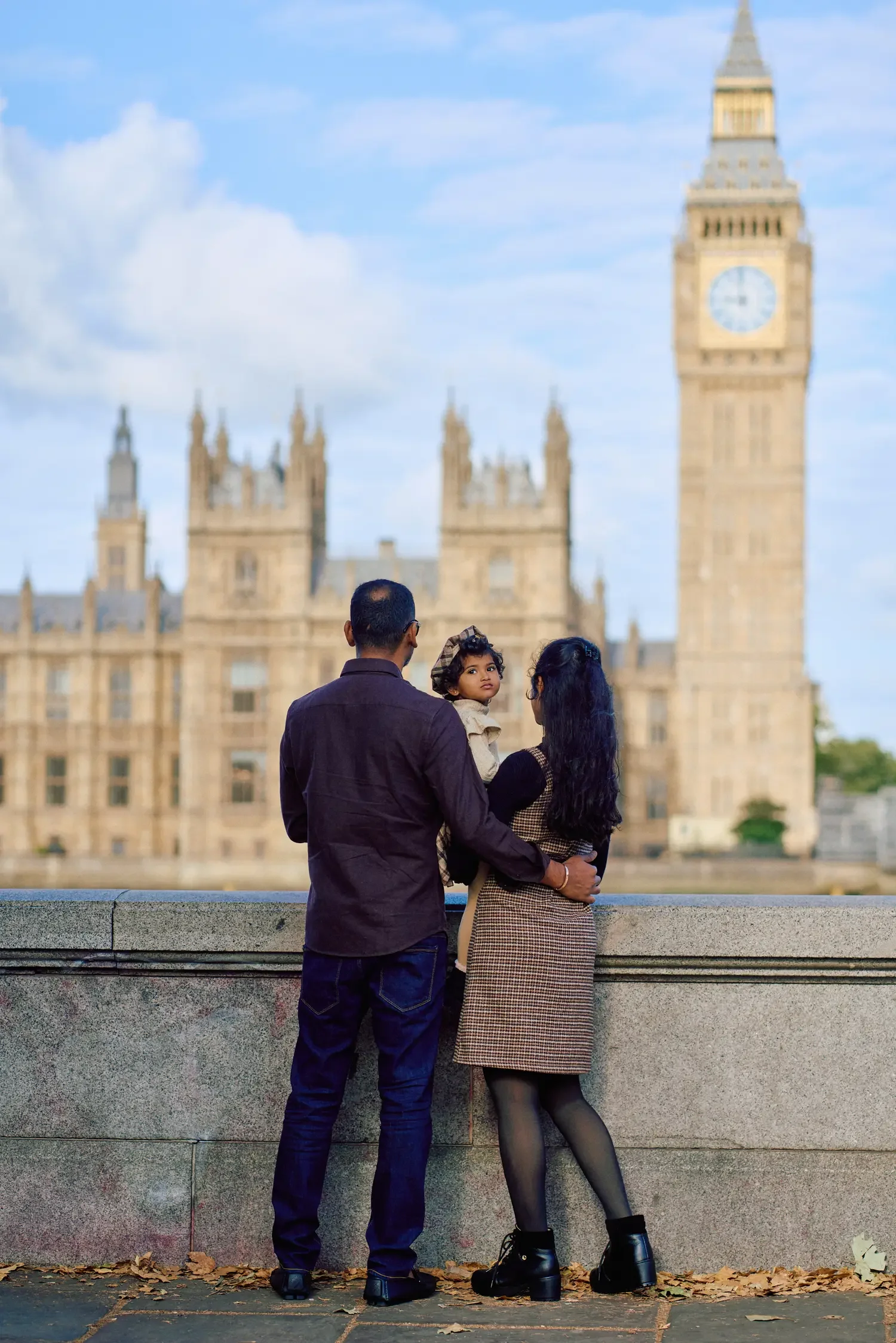 Family looking out over the Thames from the embankment with baby girls looking at the camera, London photoshoot