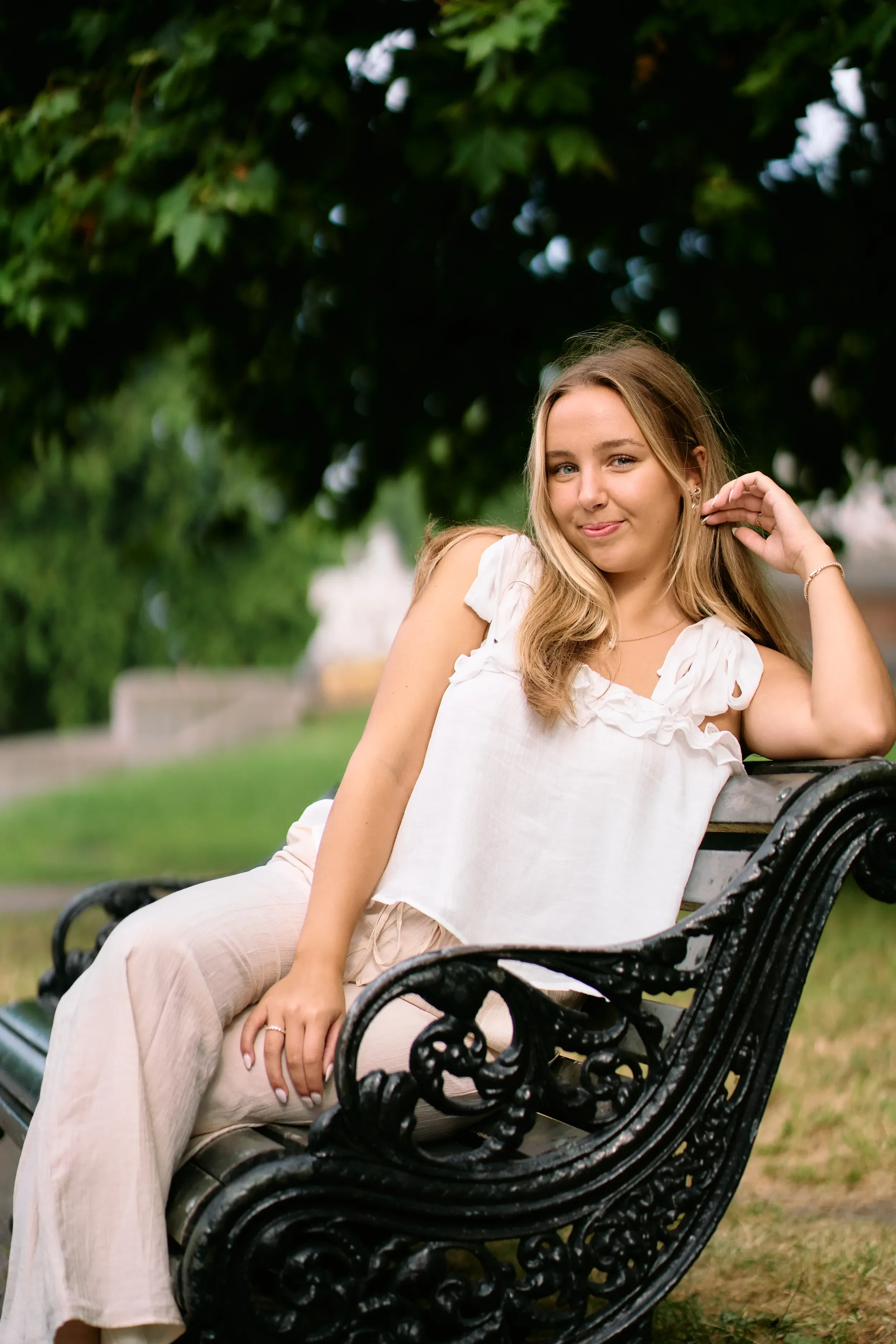 Close-up high school senior portrait with soft natural light and green bokeh in Kensington Gardens, London