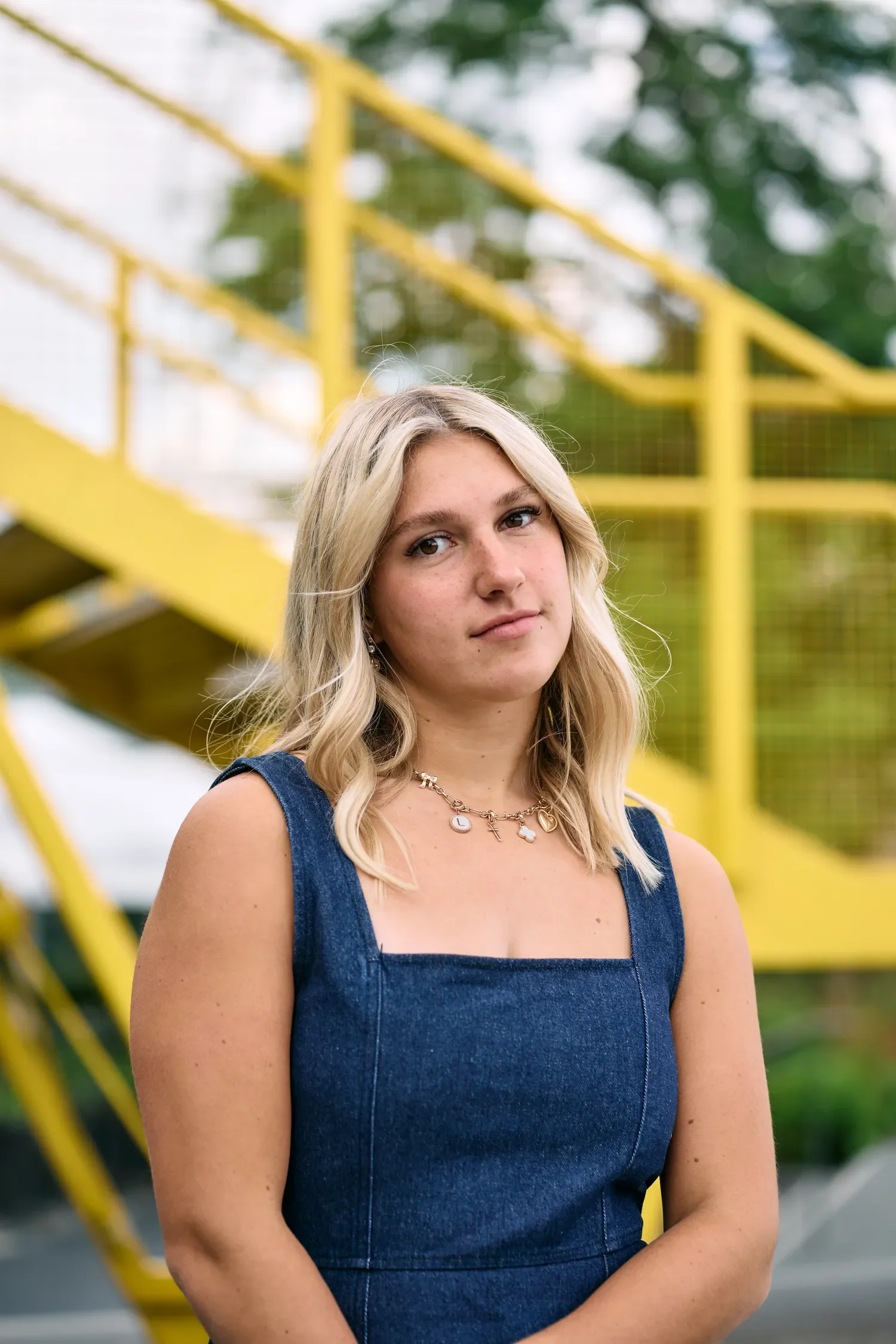 Teenage girl in a denim dress beside the yellow staircase on London's South Bank
