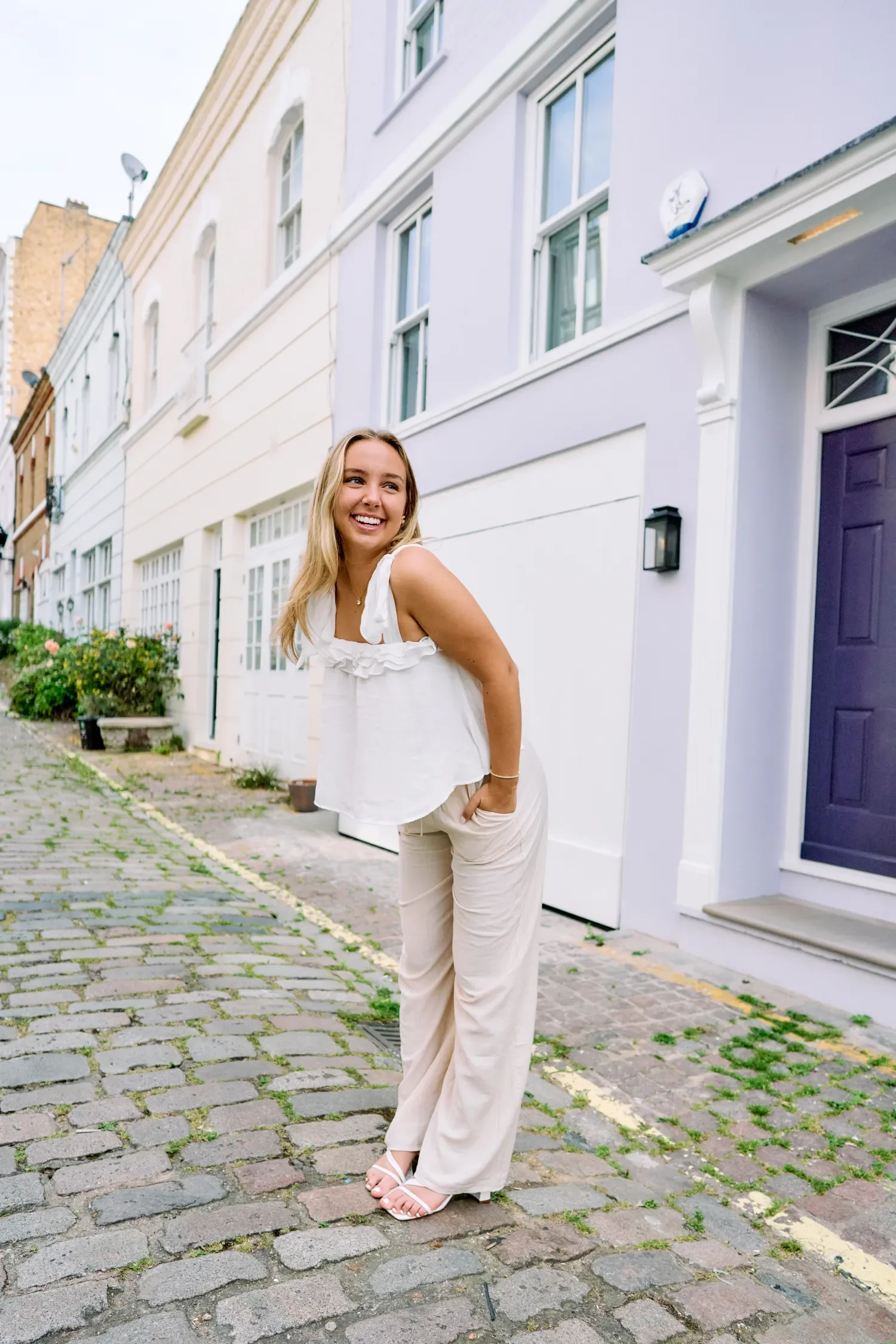 Senior portrait of a blonde woman in white on a Kensington mews street near the Royal Albert Hall