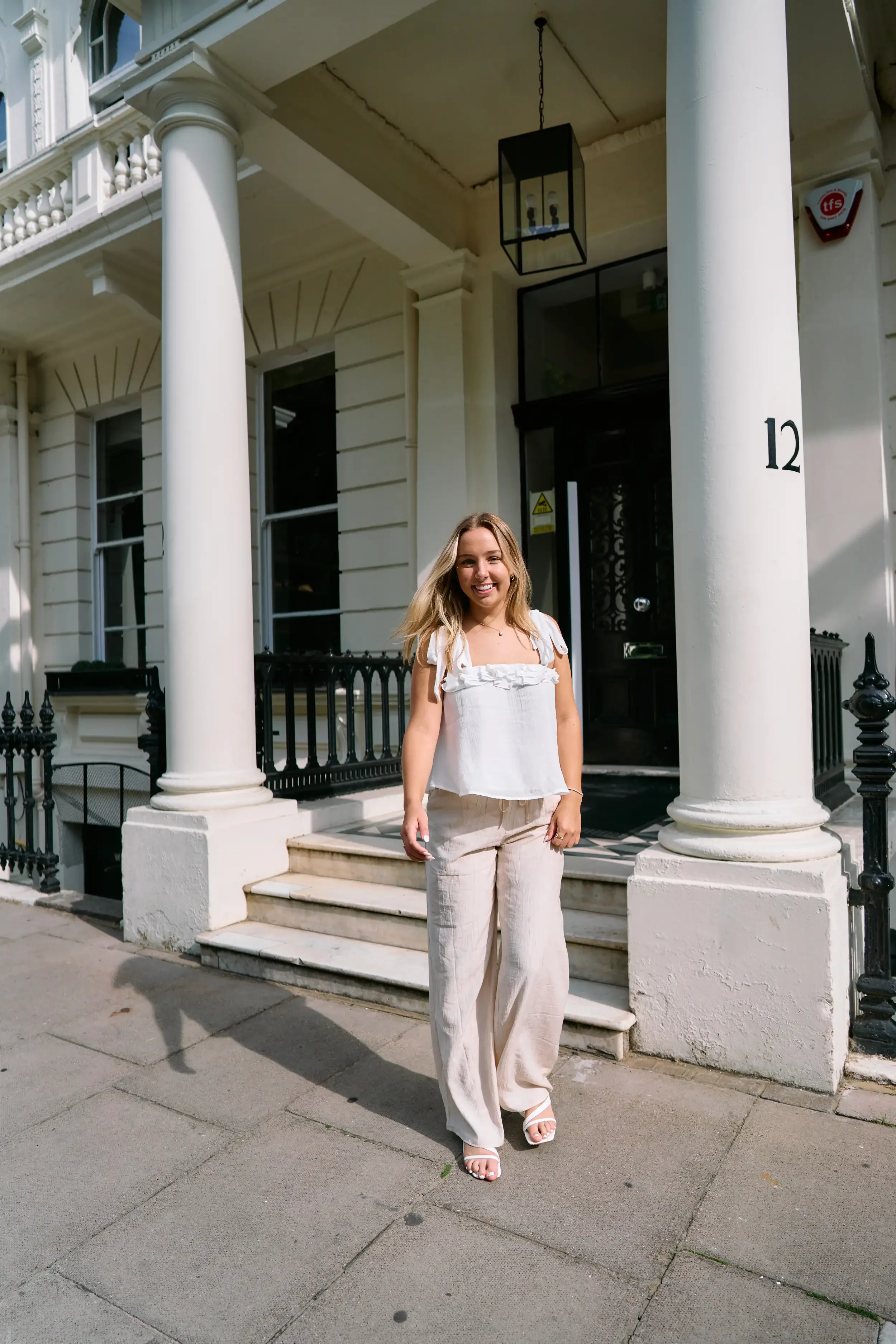 High school senior portrait outside a white stucco portico entrance in Kensington, London