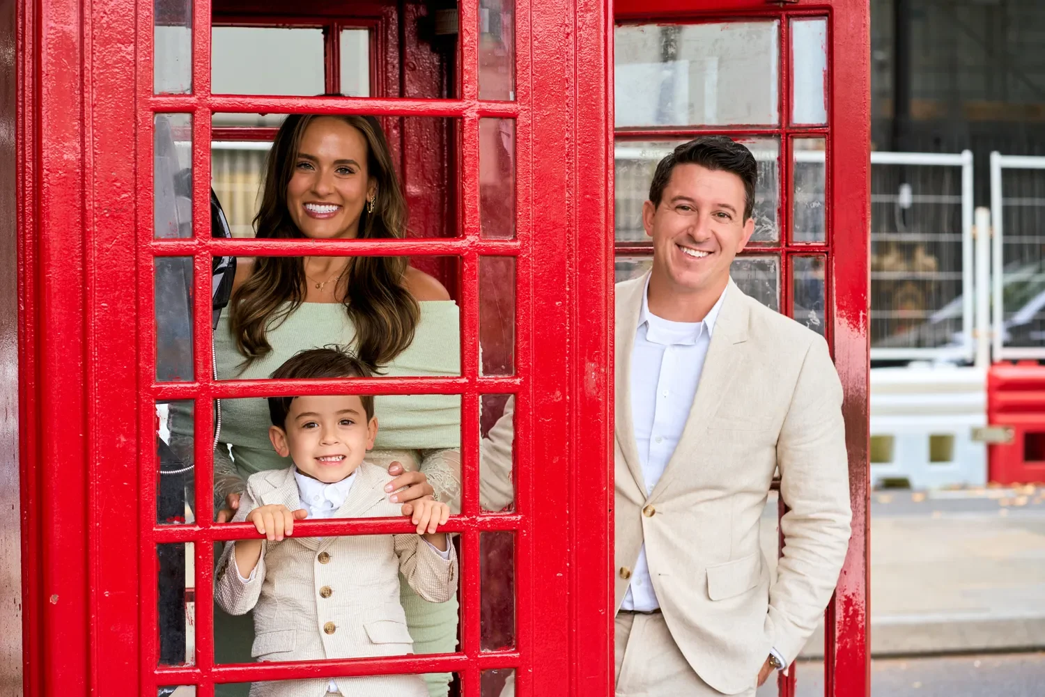 Family posing inside a red phone box near Westminster Bridge, London