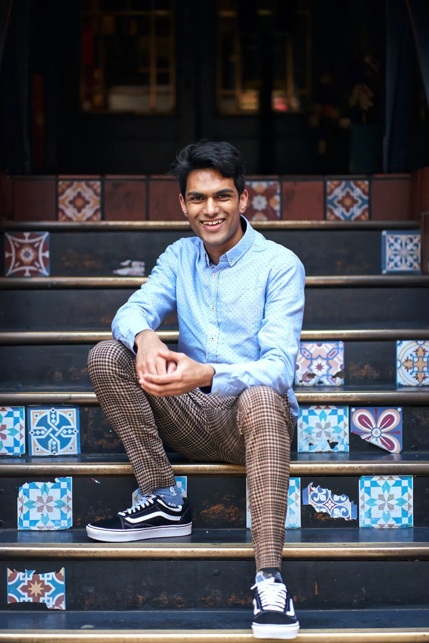 Man smiling on colourful tiled steps, Covent Garden London street style portrait