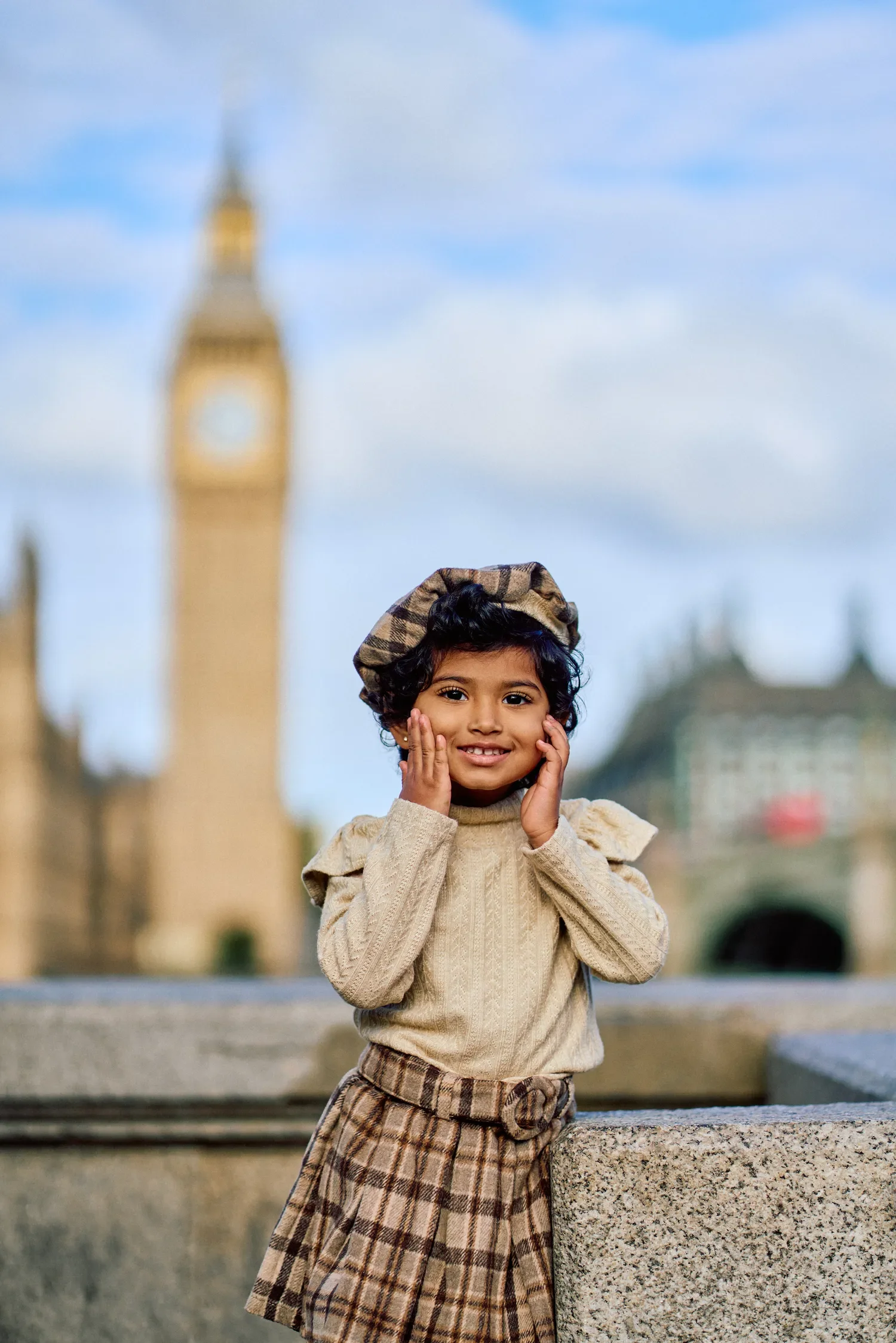 Close-up of toddler girl laughing on Westminster Bridge during family photoshoot