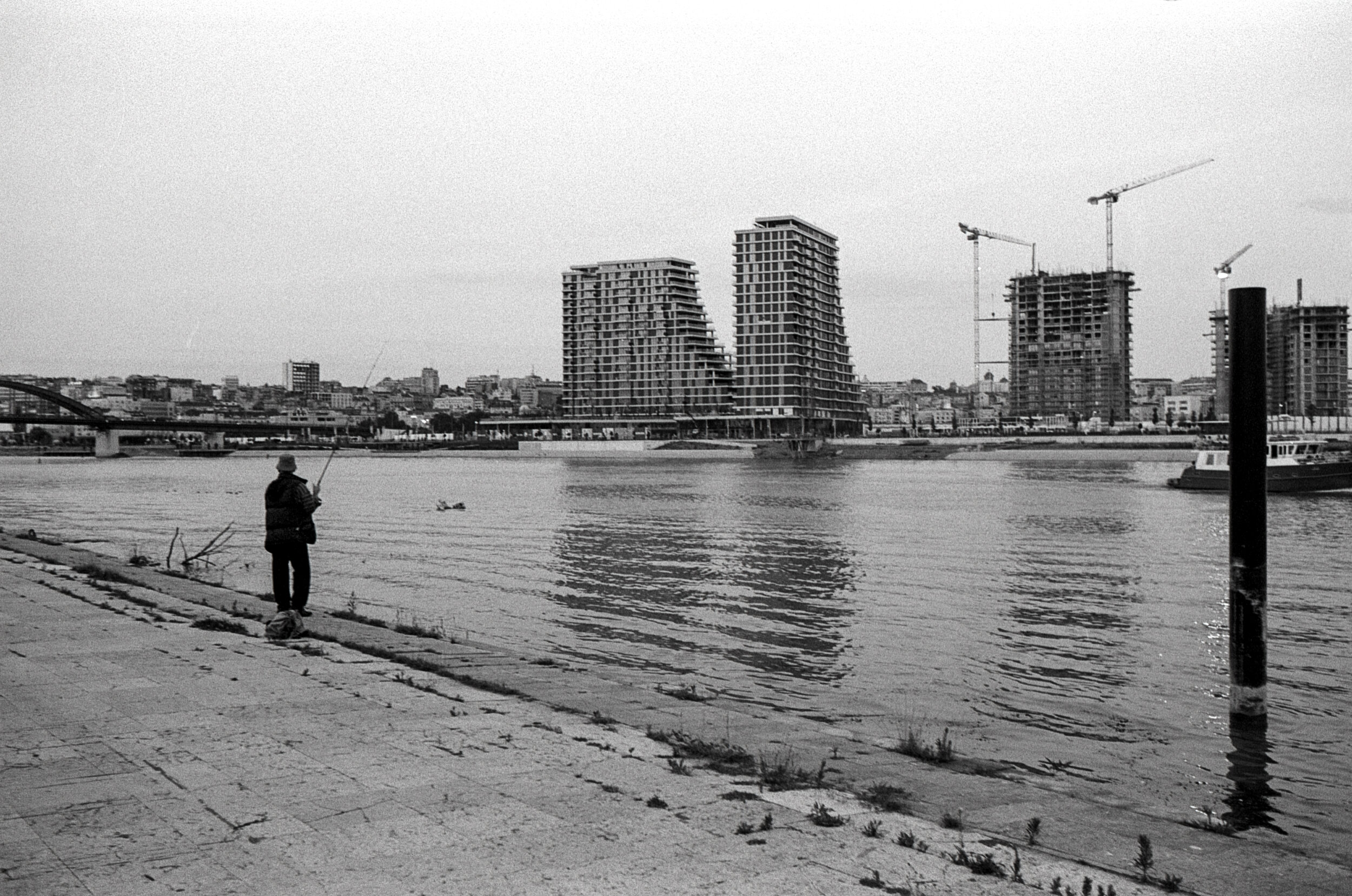 Un pescatore sul fiume Sava di fronte al cantiere del Belgrade Waterfront, Luglio 2018, Belgrado