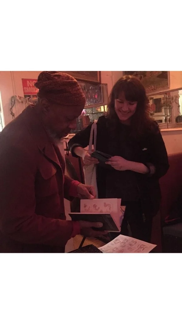 Laraaji with fan, comic artist and illustrator Leslie Stein, showing a comic she made featuring an illustration of him. .