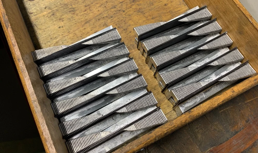 A series of combs being produced. Feet soldered and lead mass partially cut.