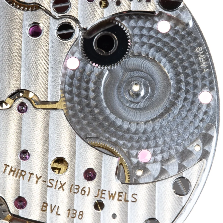 The large steel pinion meshes with the rotor pinion attached to the rotor, winding the watch.