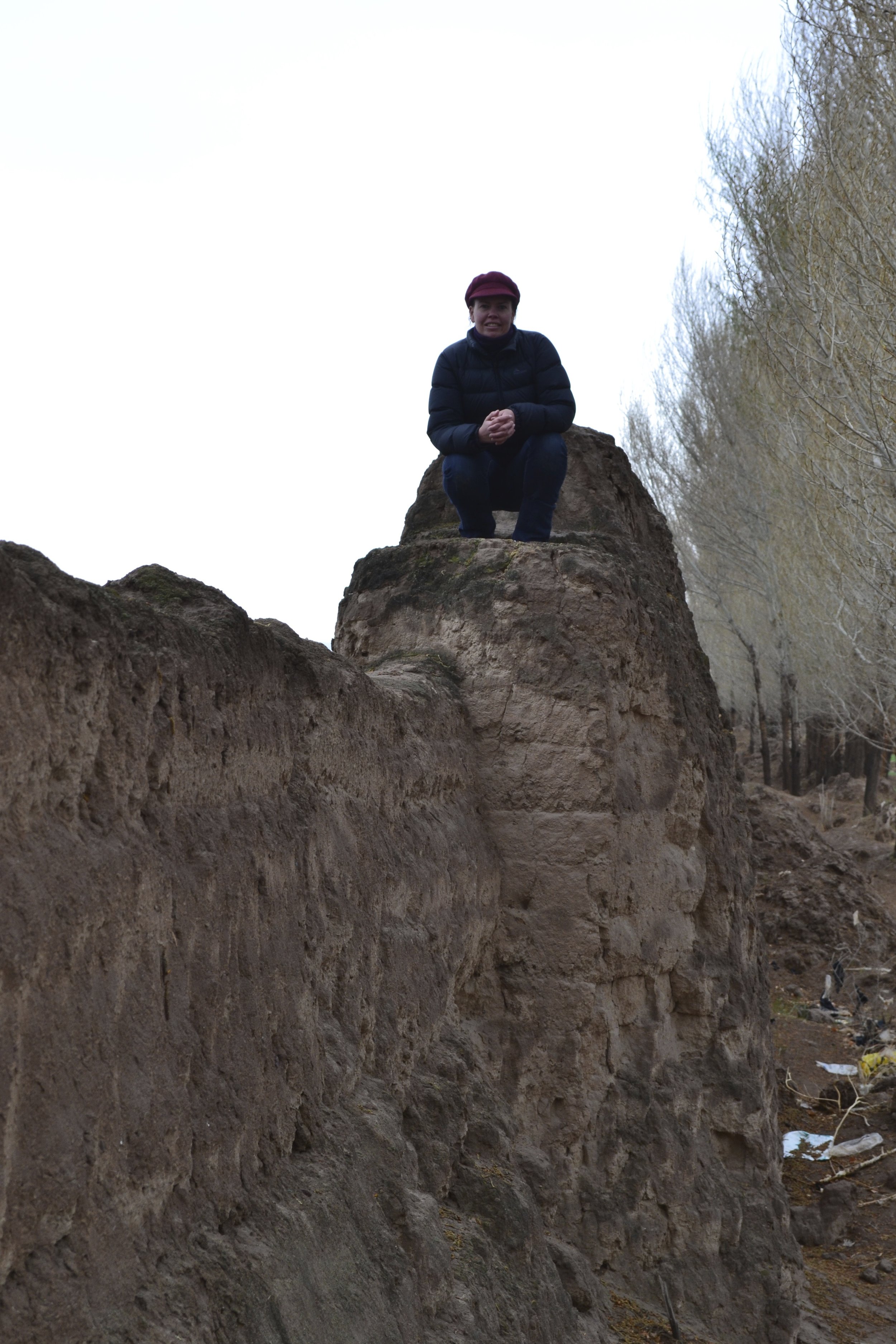 "I am standing on an old ruined part of the 'Great Wall of China' which runs right through the village I lived in in Gansu Province. Here I am clambering on top of it with no one to tell me otherwise. It runs directly through a farm I was working on that day. It looks a bit different to the tourist photos we see of the Great Wall further to the East!"