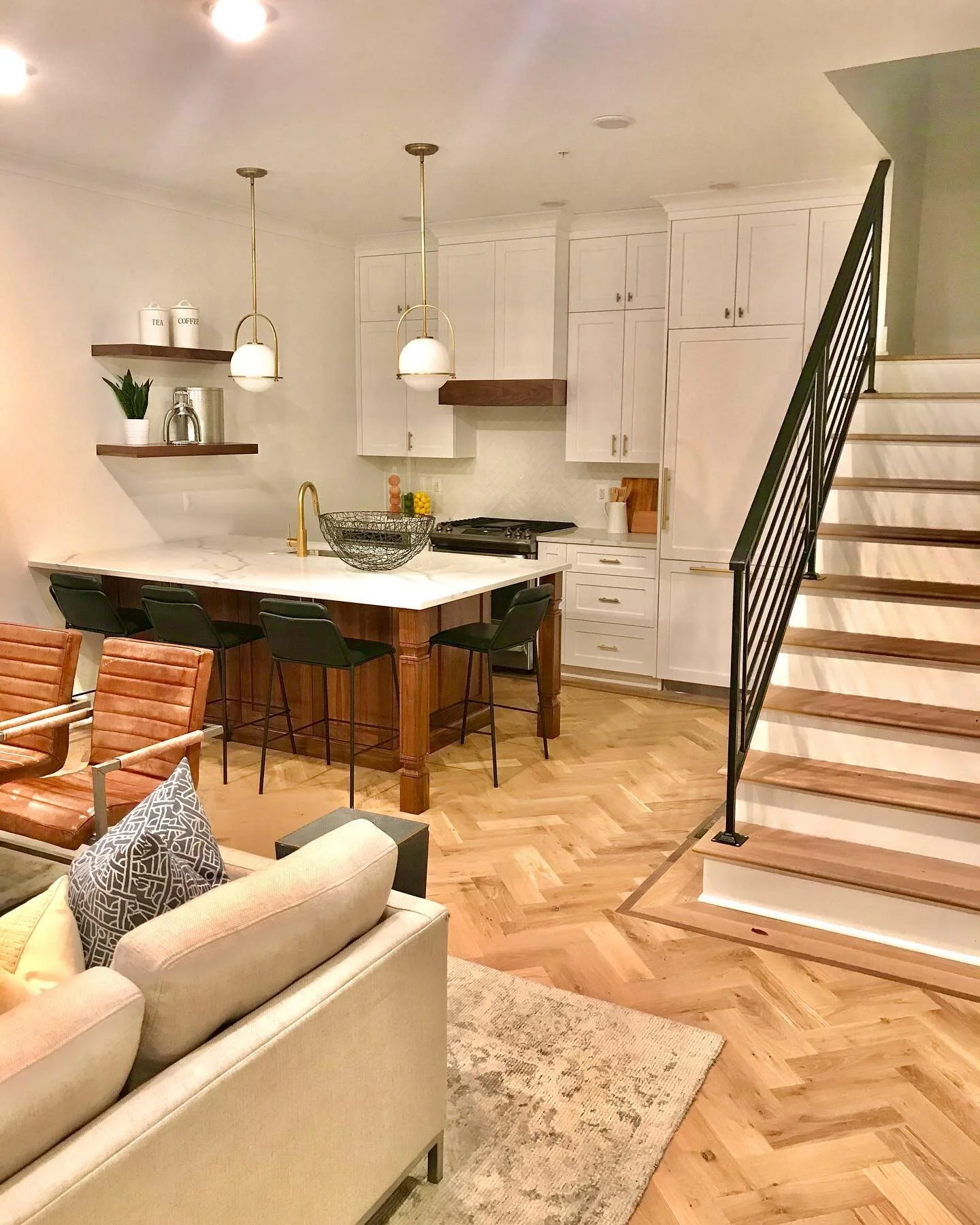 A kitchen at Otis Place Flats.  Lights off in the kitchen.  Usually everything is blindingly bright to catch your eye but we feel that the warmth and the height of this kitchen draws us in without that. The clean aesthetic provided by the paneled Bos