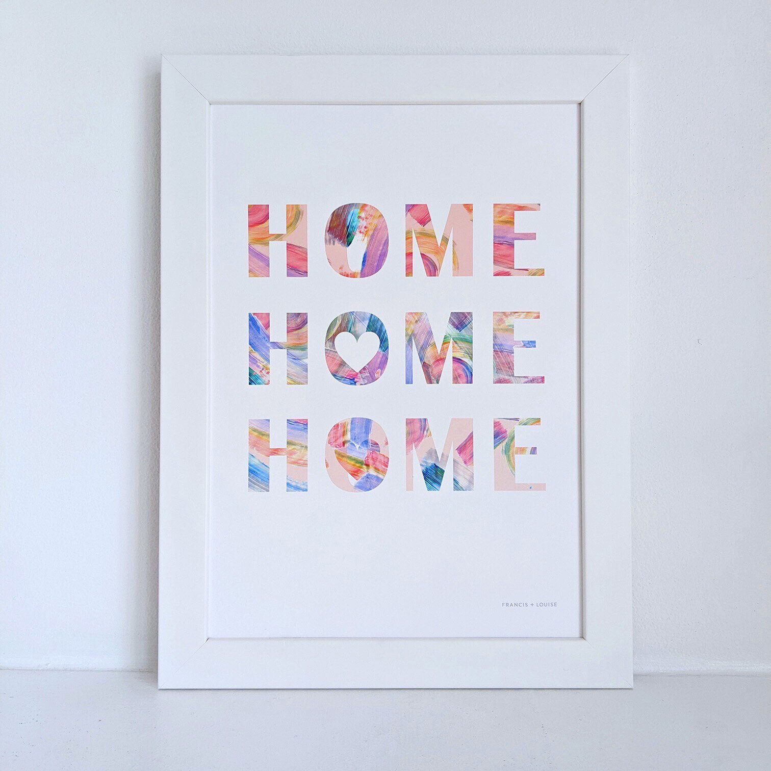 HOME TYPOGRAPHY PRINT WITH THE TEXT “HOME HOME HOME” IN MULTI-COLOURS ON A WHITE BACKGROUND