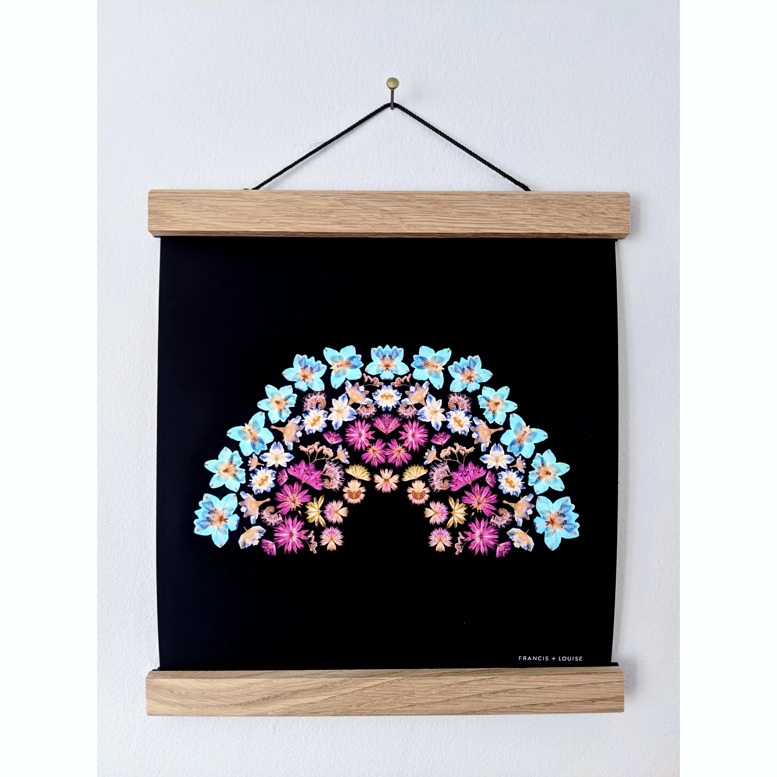 SQUARE RAINBOW ART PRINT FEATURING A RAINBOW OF PRESSED FLOWERS ON A DARK BLUE BACKGROUND 