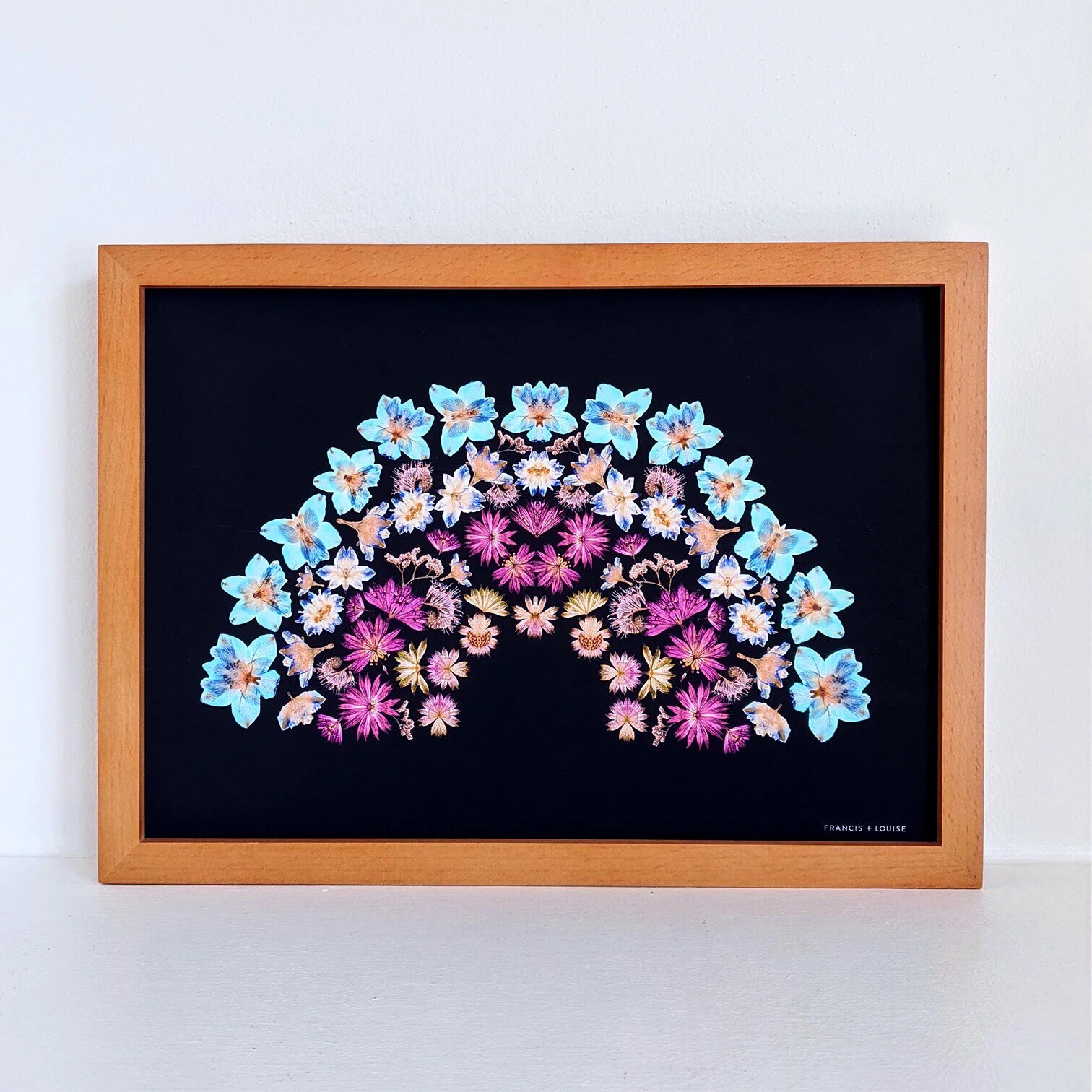 A4 RAINBOW ART PRINT FEATURING A RAINBOW OF PRESSED FLOWERS ON A DARK BLUE BACKGROUND 