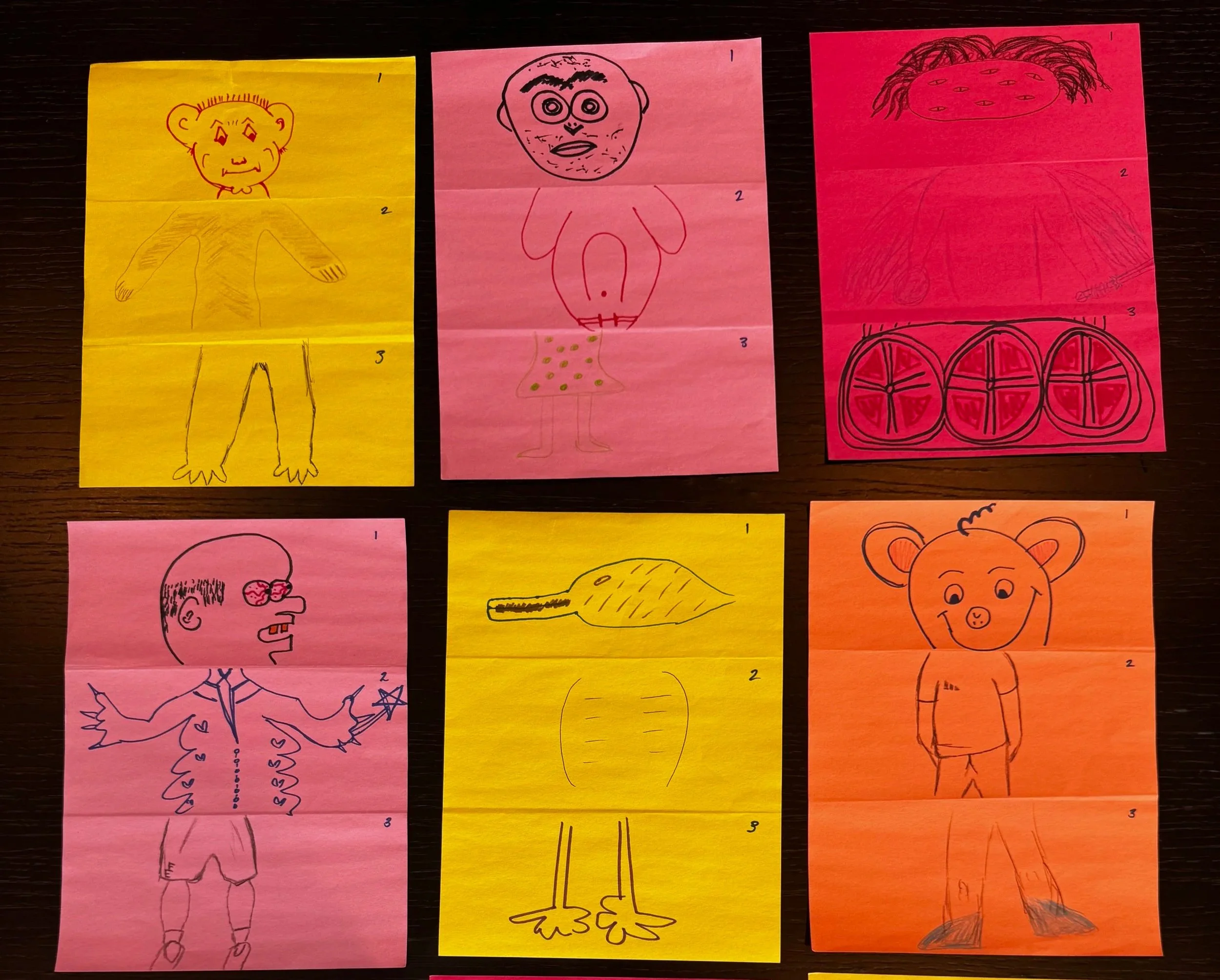 Coloured pieces of paper with different drawings of weird and wacky creatures.