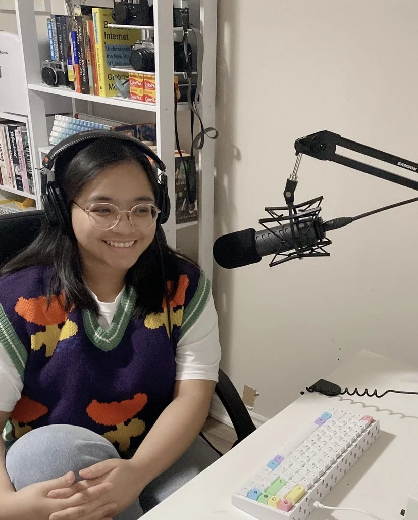 Trisha sitting in front of a keyboard with headphones on.