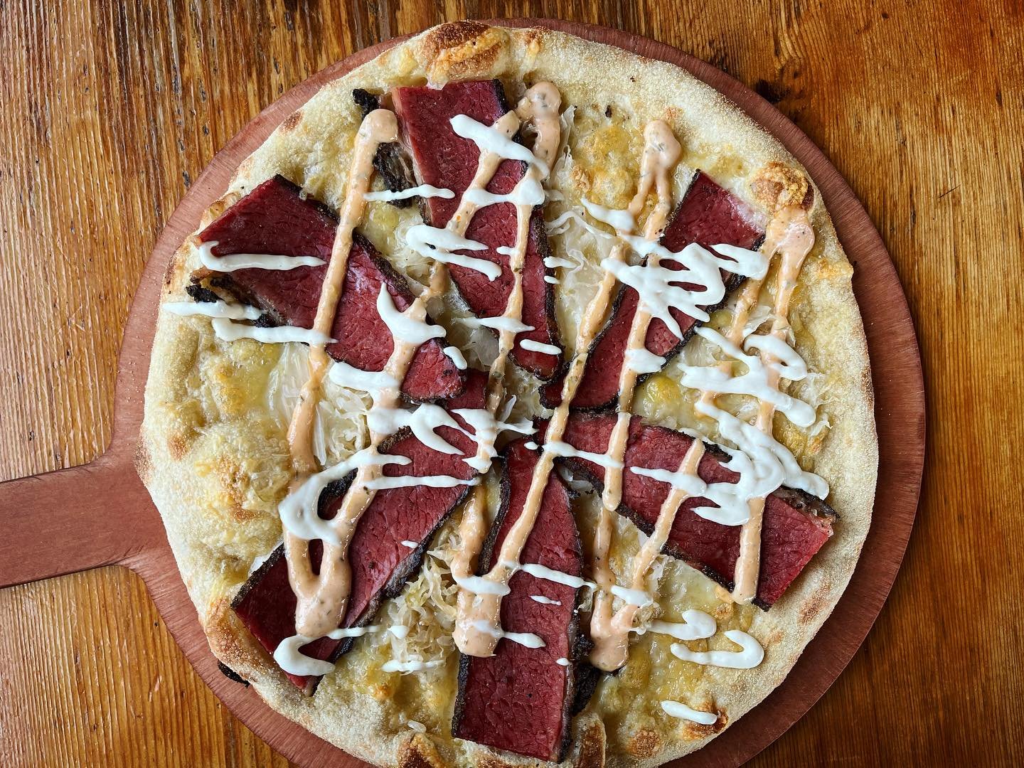 Have you had our Reuben Pizza?! It's back on special! Swiss cheese, sauerkraut, Train Wreck Bar &amp; Grill smoked pastrami, finished with house thousand island and horseradish sauce, $18.