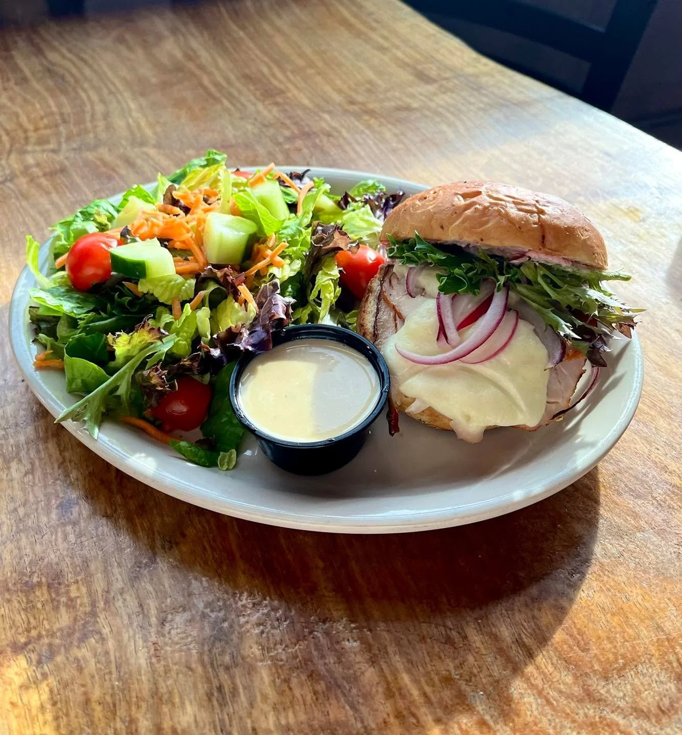 The Gobbler 🦃 A smoked turkey sandwich with a spiced cranberry and cream cheese spread, fresh mozzarella, spring mix and red onion, served on a Train Wreck Bakery Garlic Rosemary Bun. Comes with your choice of soup or salad, $18.
