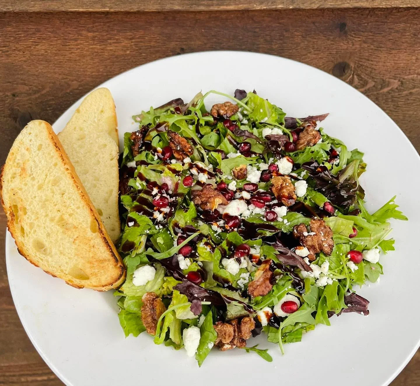 Our new Winter Pomegranate Salad is made with mixed greens, arugula, feta, pomegranate arils, and candied walnuts. Served with a balsamic drizzle and your choice of dressing. Level it up by adding wood fired wild Coho salmon, garlic or spicy roasted 