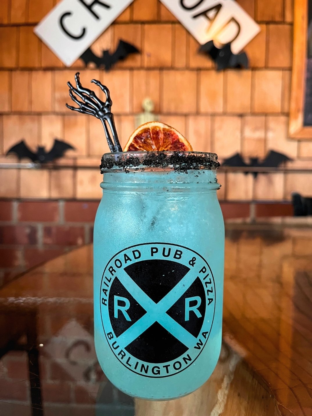 Spooky season is here! Our Zombie Margarita is made with Craftwell Cocktails Margarita, muddled with mandarin oranges, mandarin orange juice, and lime simple; topped with lemon lime soda and served with sugar rim.