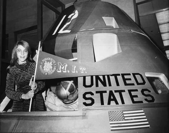 Margaret Hamilton poses with an MIT pennant inside an Apollo lunar capsule model. (Credit: MIT Museum)