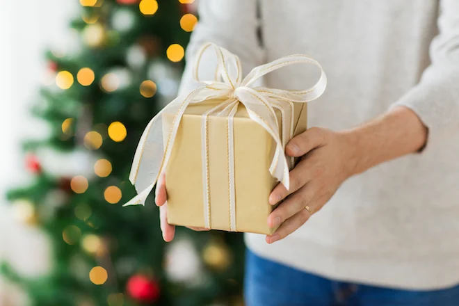close up of man with christmas gift at home