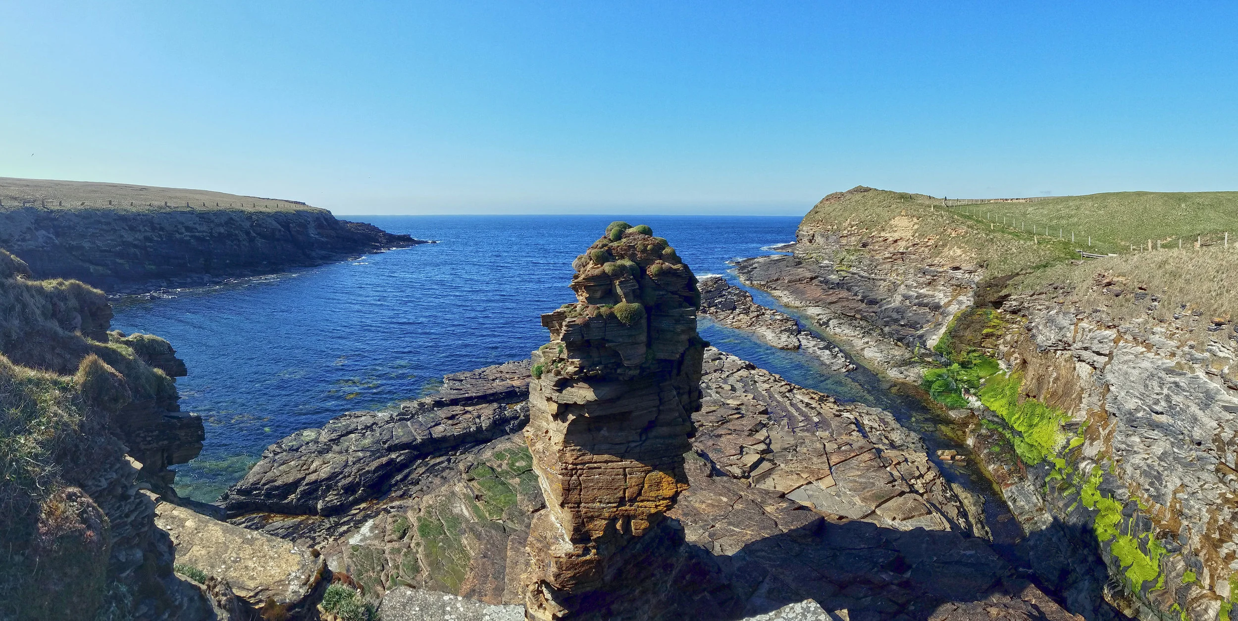 Borwick Castle sea stack at center, with the top of the Broch o' Borwick poking up at the top of the cliff at the top right.