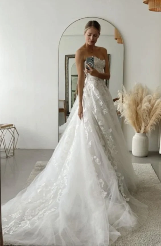 A person trying a gown in our wedding dress shop.