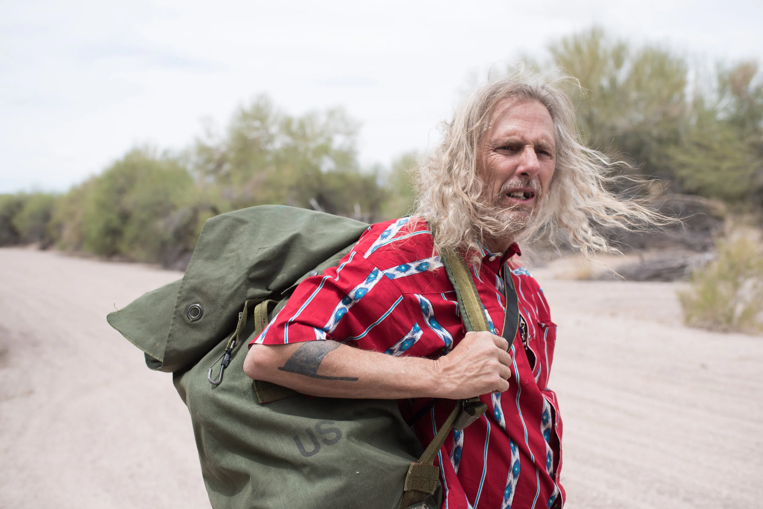 Joel carries close to 100 pounds of water in a duffel bag from his military days.jpg