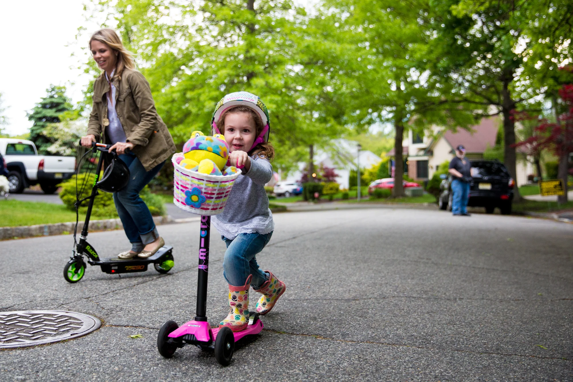 Woman and girl ride scooters on the street