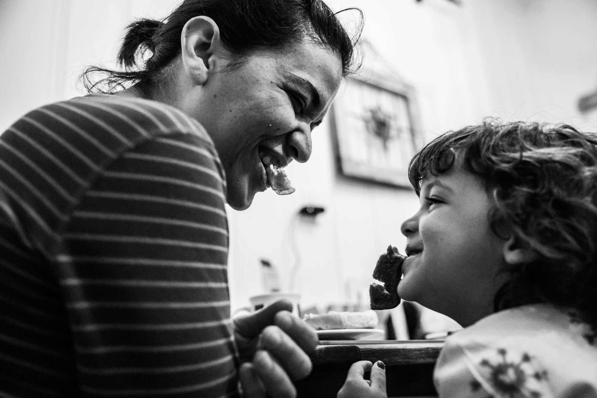 Woman and girl with bites of french toast sticking out of their mouths