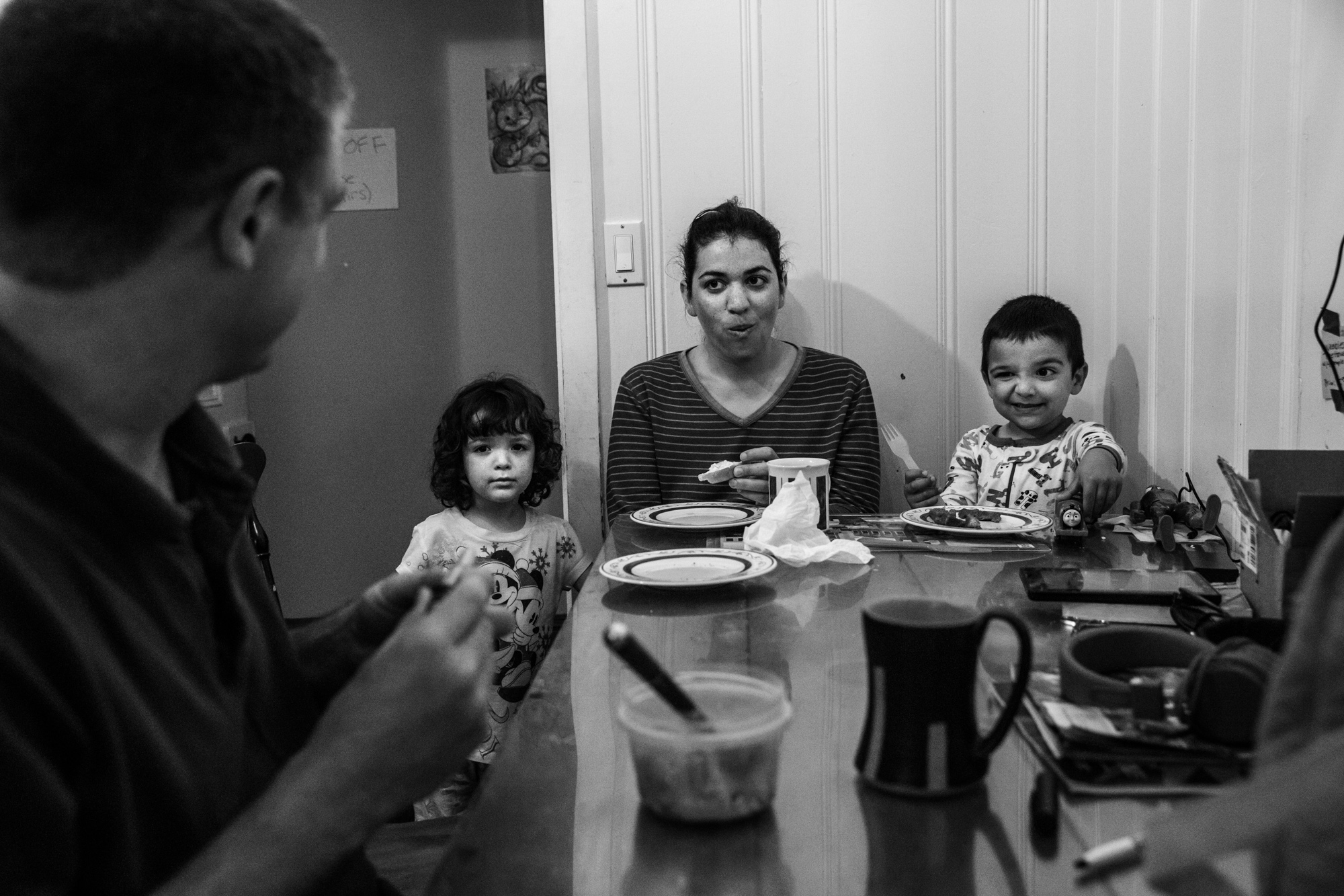 Man looks at girl, woman, and boy winking at the end of the table