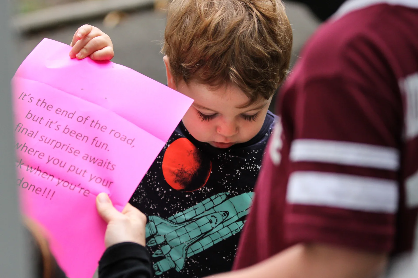 Boy holds up paper to mother to read