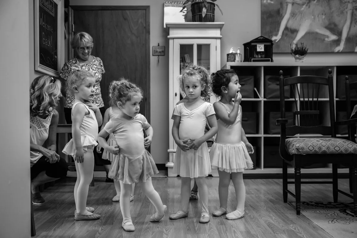 Girls line up nervously in their ballet clothes before class