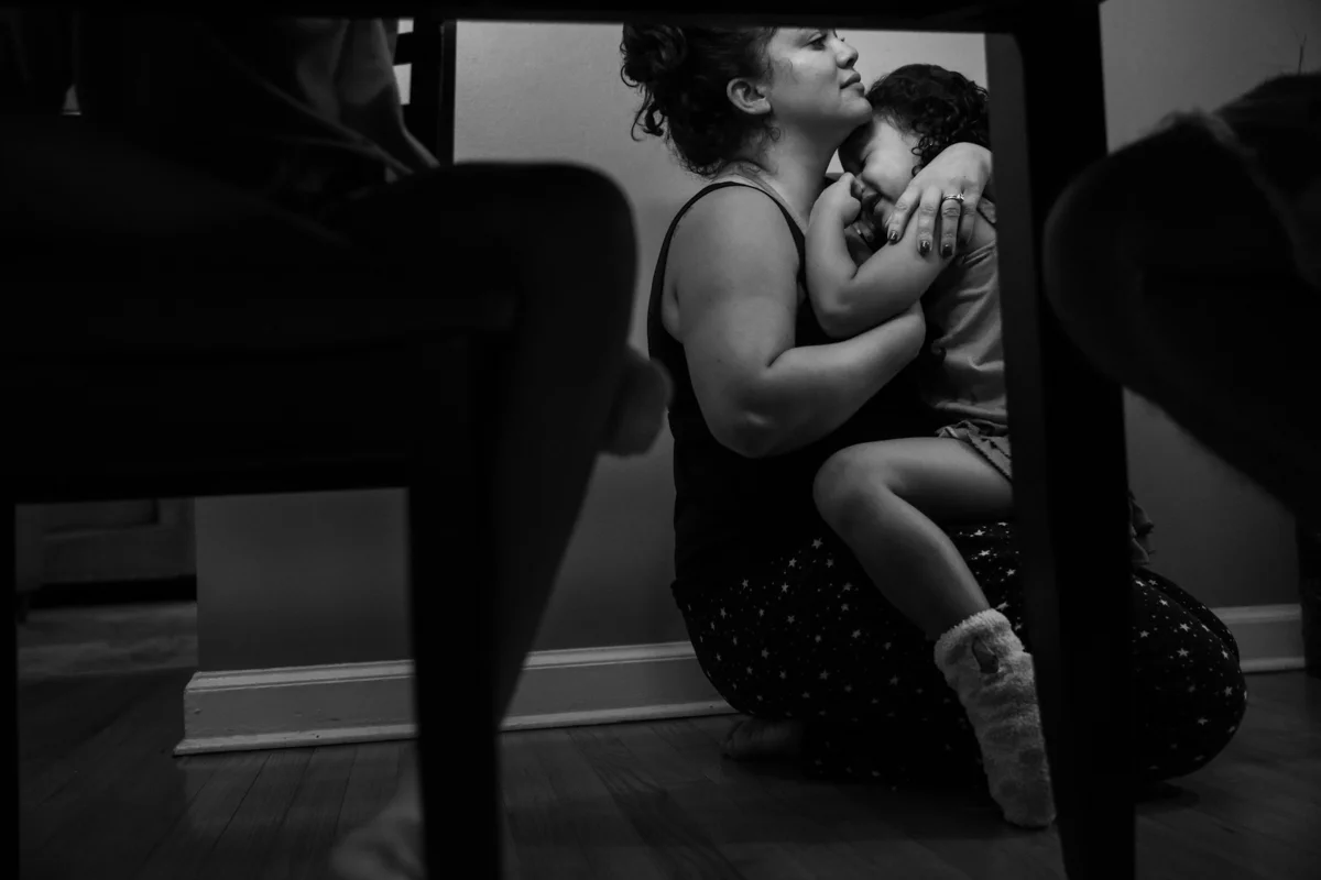 Woman holds crying girl on the floor