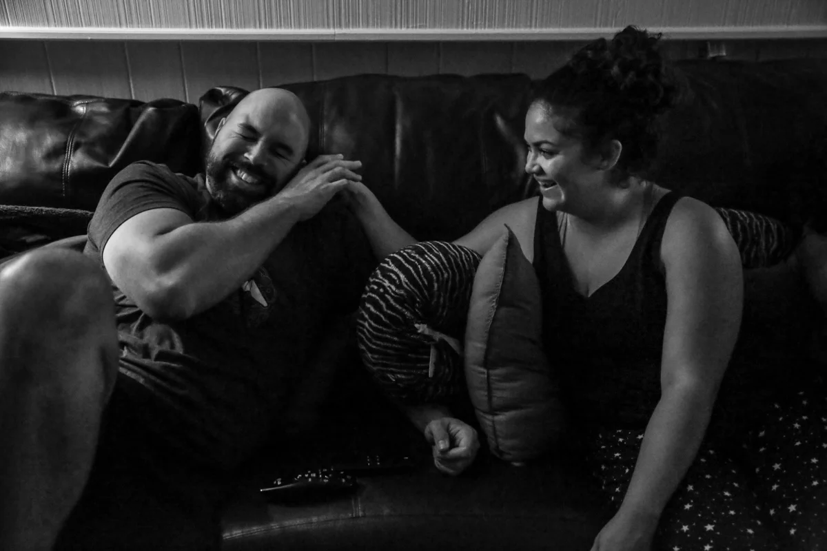 Man laughs while trying to stop woman from picking at his beard