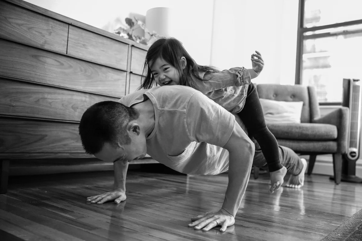 Girl lays on man while doing a pushup