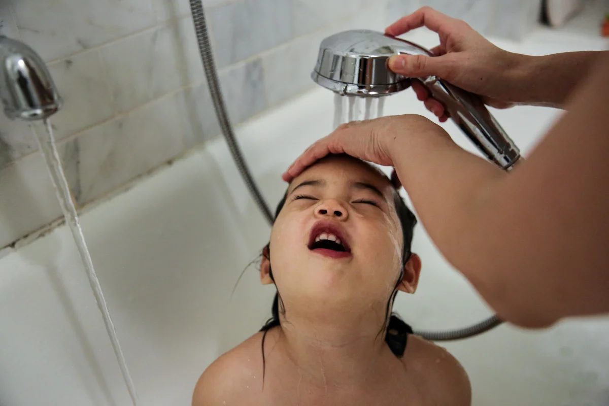 Girl gets her hair washed in tub