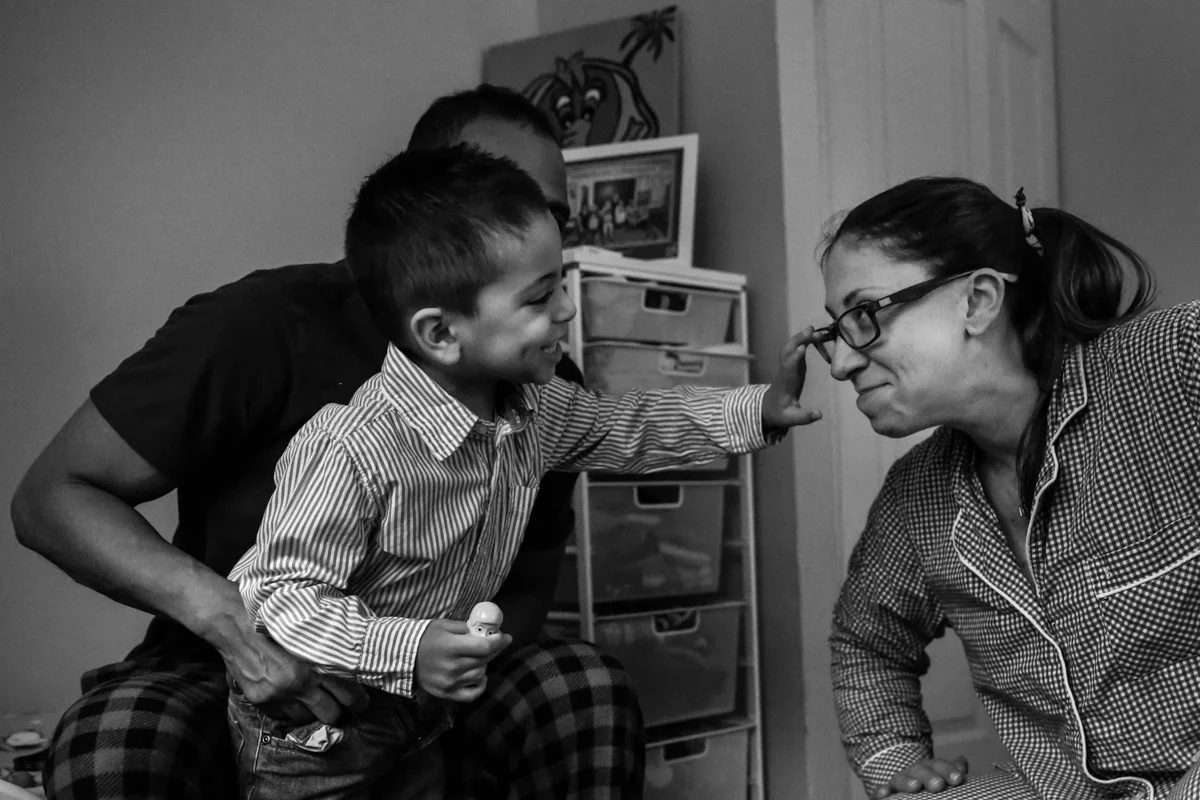 Boy reaches for woman's glasses on her face