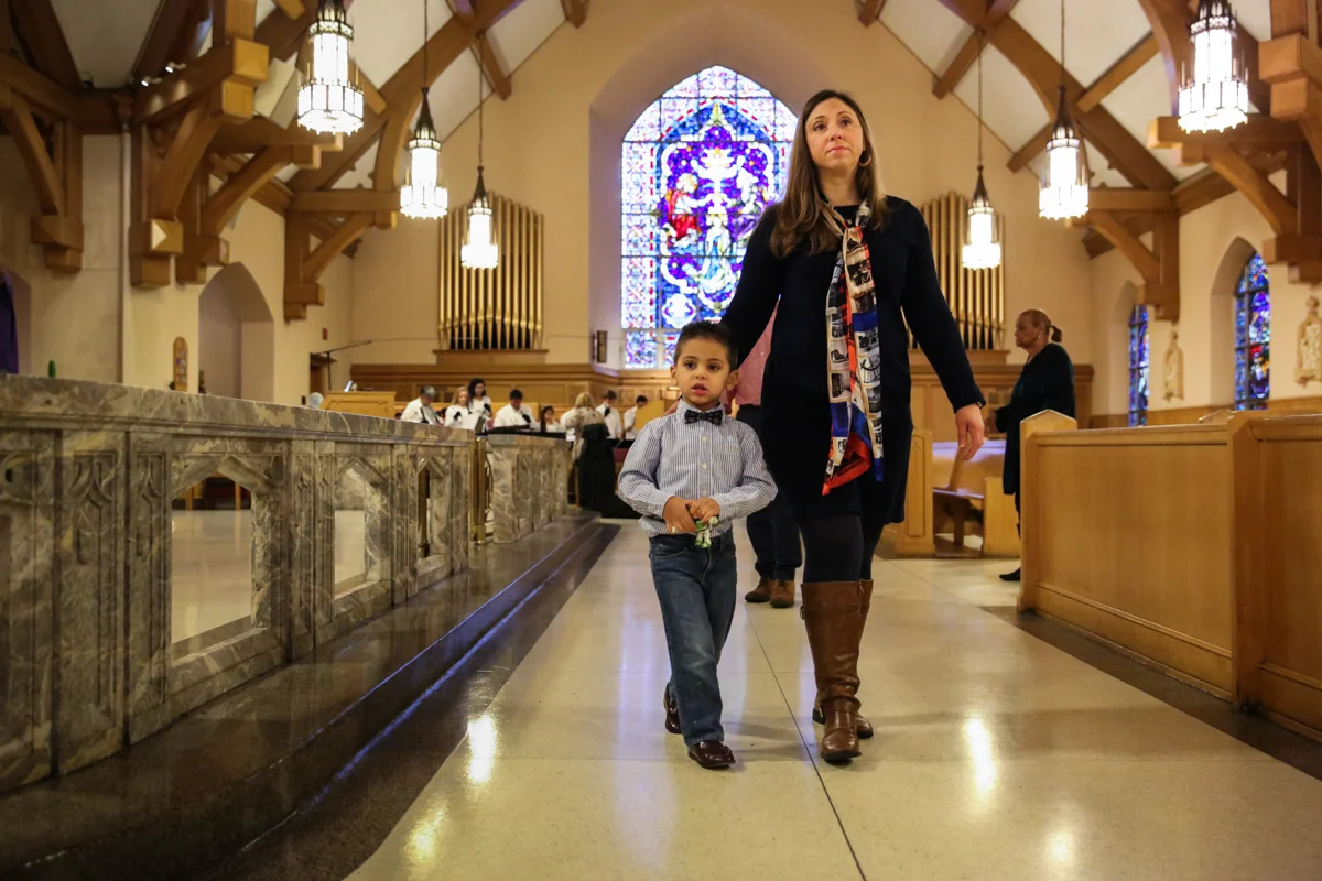 Woman and boy walk down aisle in church
