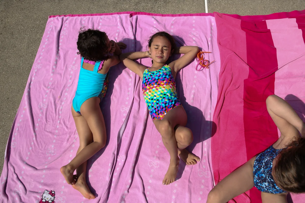Girls sunbathe on pink towels