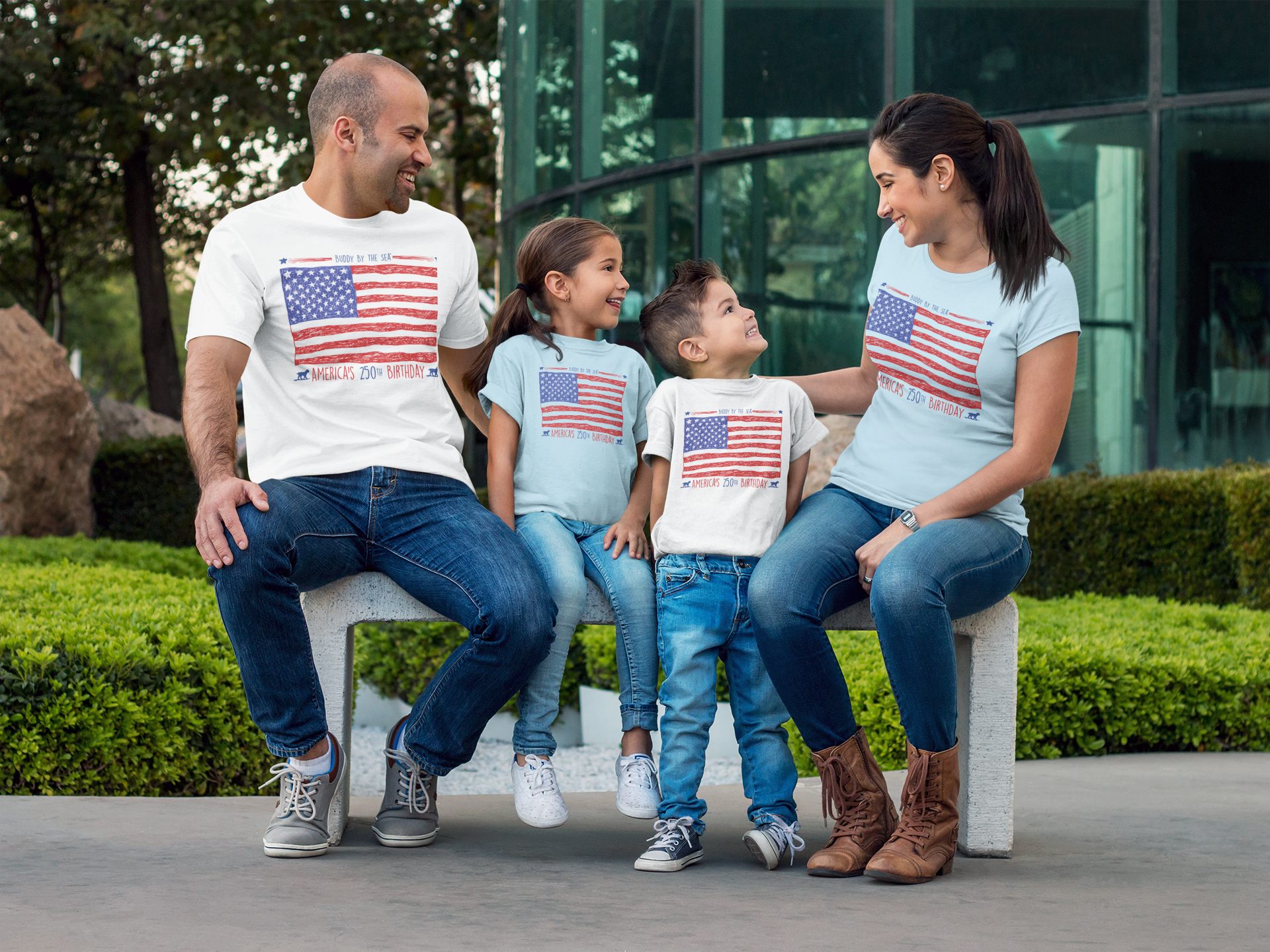 couple-with-kids-wearing-different-tees-mockup-sitting-on-a-bench-while-outdoors-a15484.png