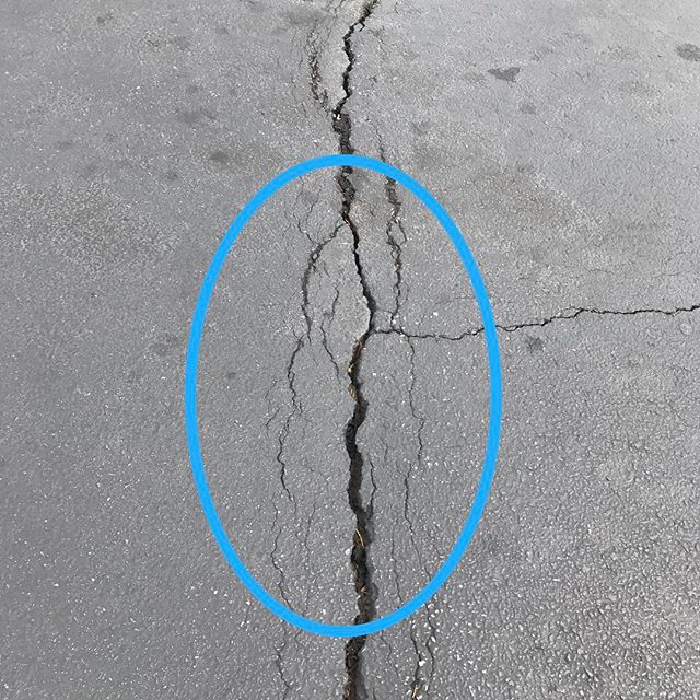 This is a great example of what happens when cracks are left to allow water to penetrate the sub-grade. Notice the pavement starting to fail on the sides of the crack. This is starting to be a failed area &amp; a pothole will form here soon.