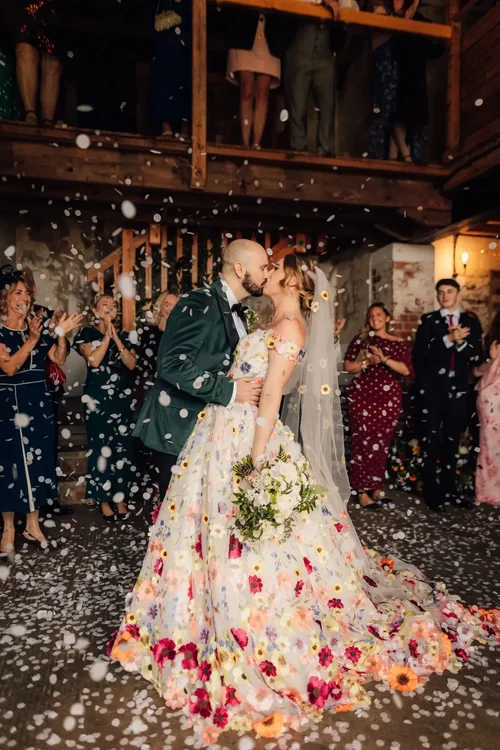 Matt and Nic under a shower of confetti at Woolas Barn