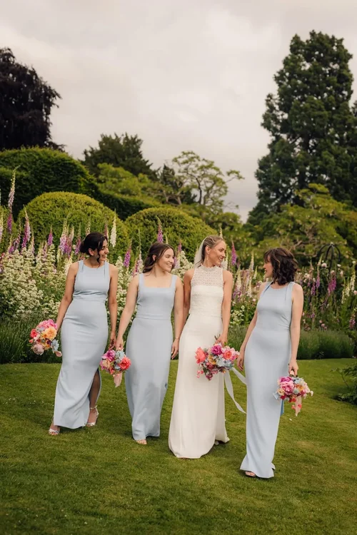 Bridesmaids walking together through a garden