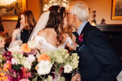 A couple sharing a kiss at their wedding breakfast