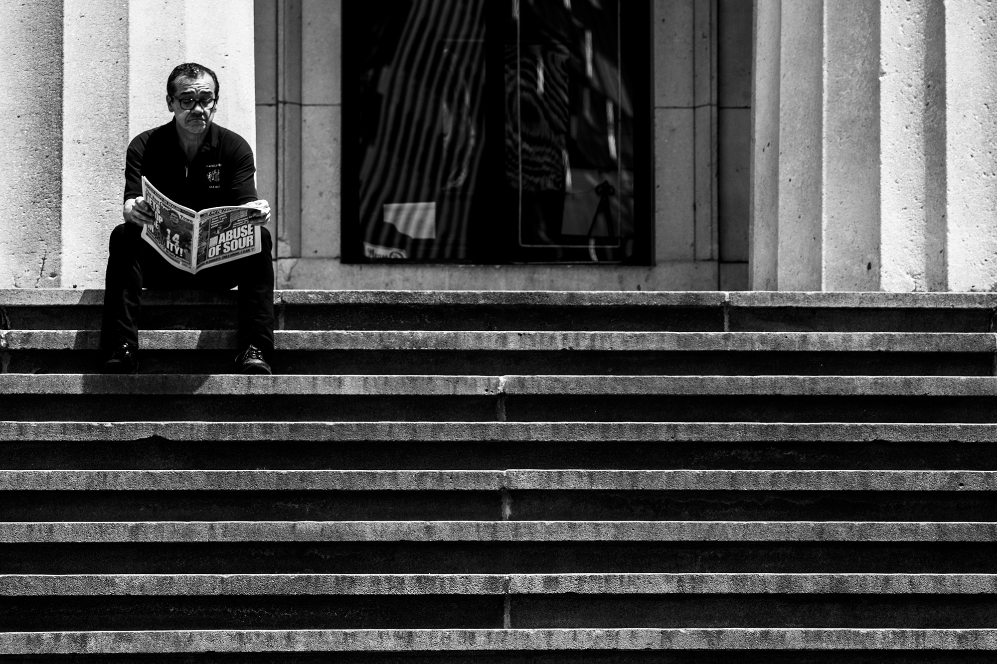 Man Reading a Newspaper on The Steps of Federal Hall