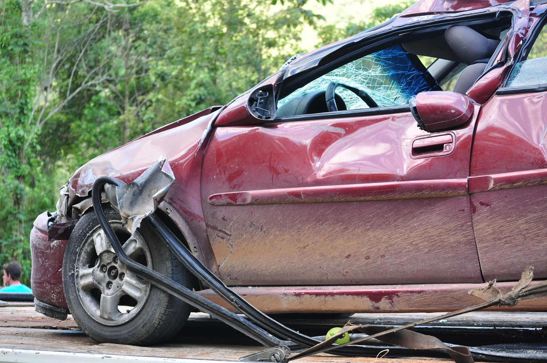 Photograph: Red car on flatbed with smashed front end from a collision.