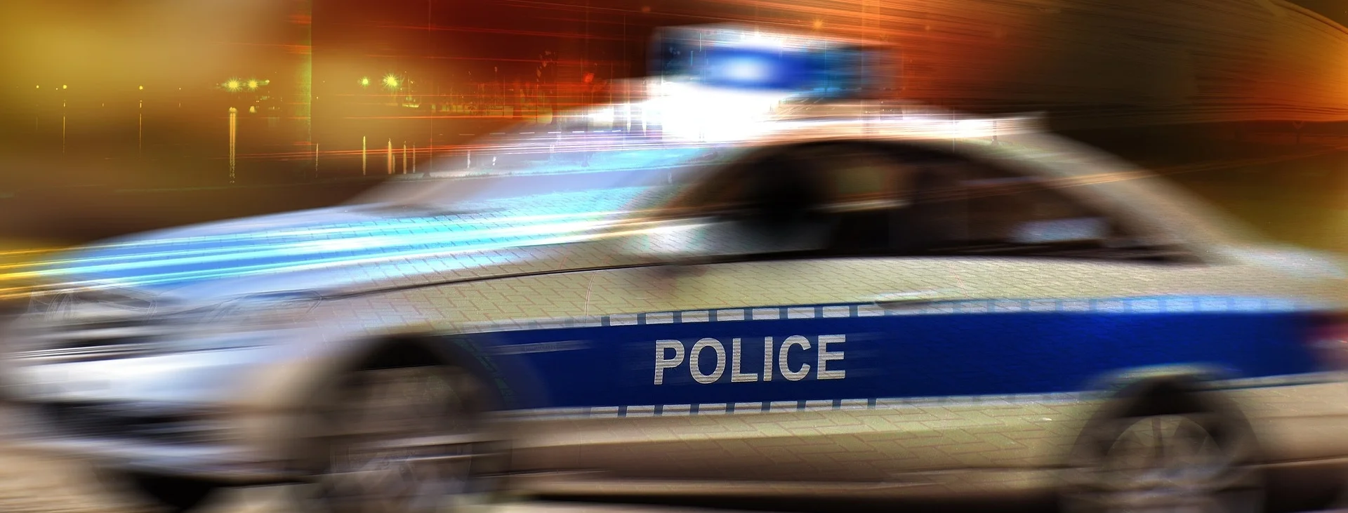 Photograph: Police car racing with its emergency lights on.