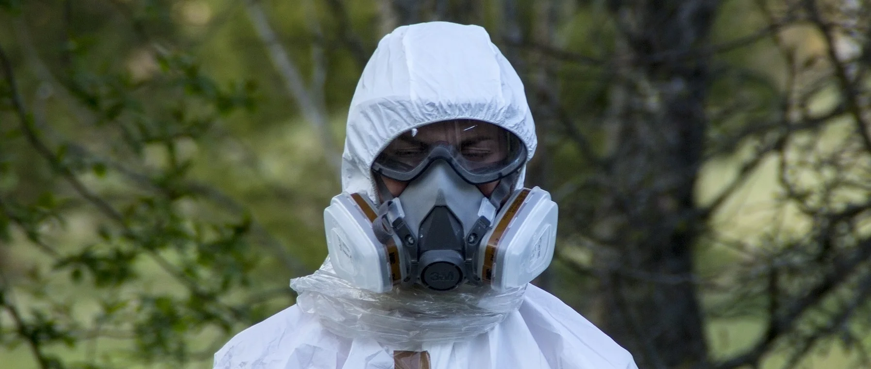 Photograph: Person in hazmat suit with hood and ventilator to prevent asbestos inhalation.
