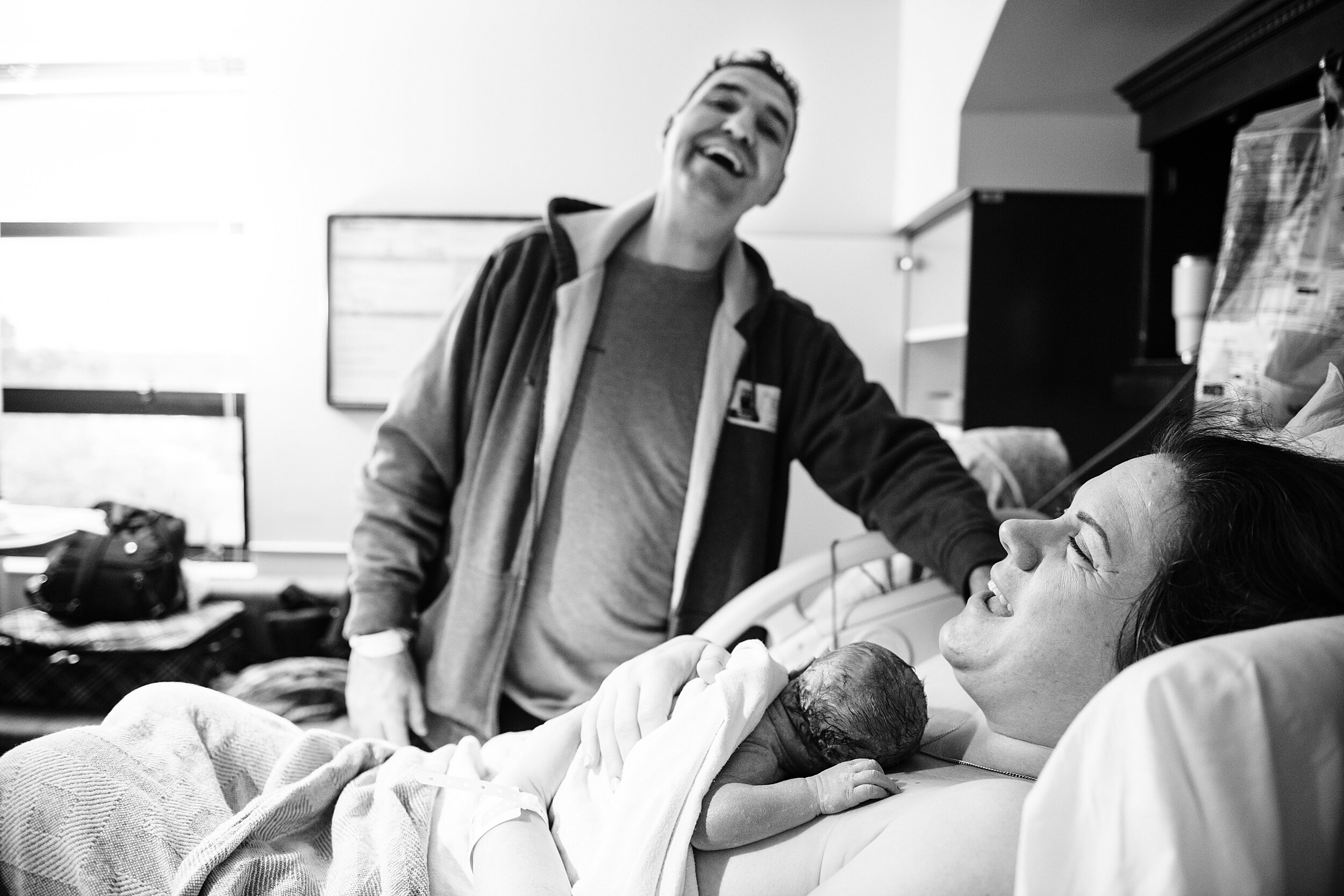 father admiring his partner and newborn baby in a Pensacola hospital